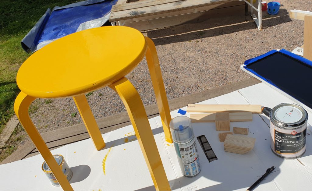 Ikean keltaiseksi maalattu jakkara kuivumassa auringossa. 