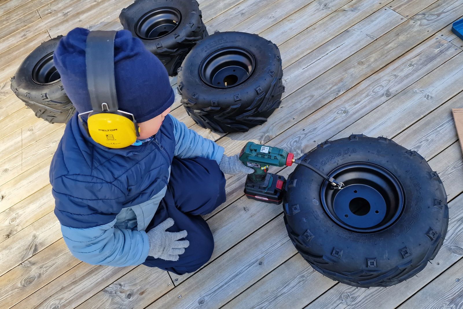 Lapsi täyttämässä mönkijän renkaita. 